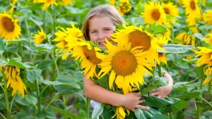 girl hugging sunflower